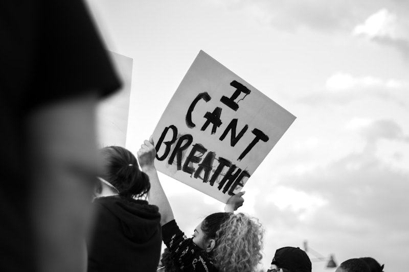 A protestor holding a sign saying "I can't breathe" at a Black Lives Matter protest